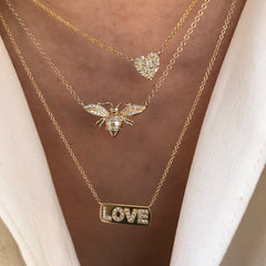 love plaque custom necklace in solid 14k gold layered with other liven necklaces